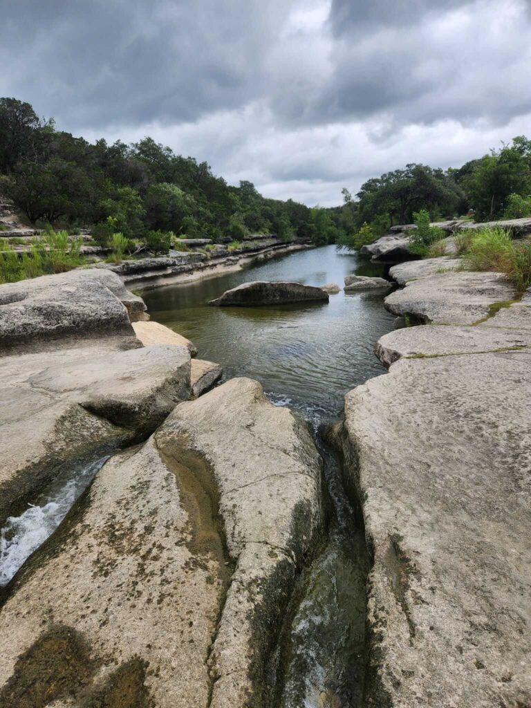 Green belt, rocks, and a gray sky. for a brand copywriting blog titled "ATX Summer Survival Guide". 